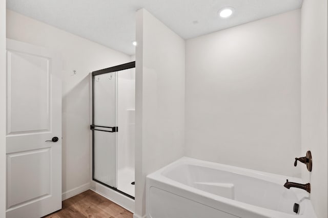 18872 Fillmore St NW, Elk River, MN 55330 - full bathroom featuring a garden tub, a shower stall, wood finished floors, recessed lighting, and baseboards