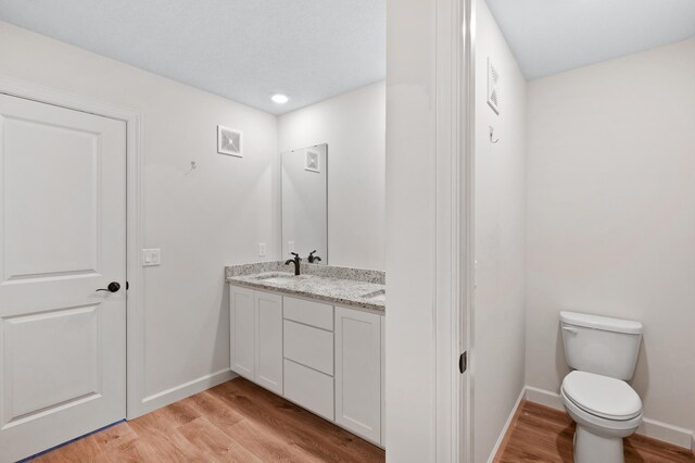 18872 Fillmore St NW, Elk River, MN 55330 - bathroom featuring wood finished floors, baseboards, double vanity, and recessed lighting
