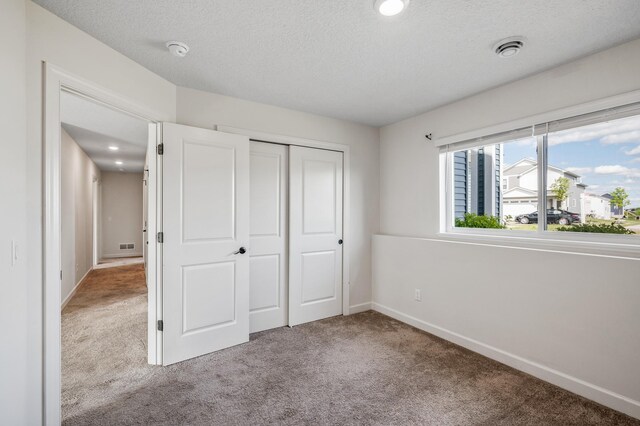 18872 Fillmore St NW, Elk River, MN 55330 - unfurnished bedroom with carpet flooring, baseboards, a closet, and a textured ceiling