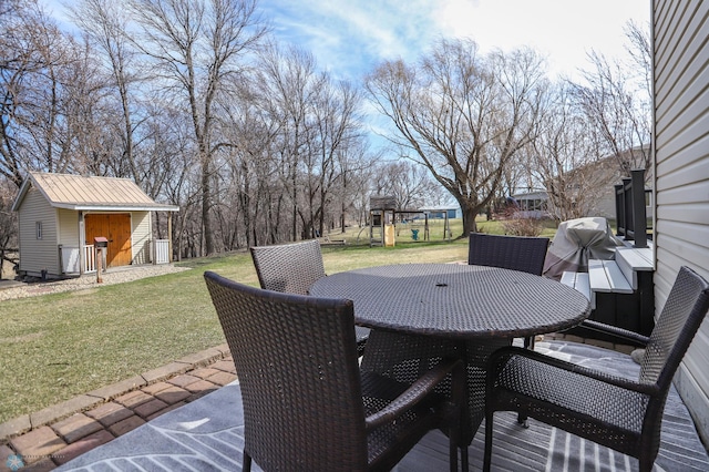 1311 Cossette Dr S, Fargo, ND 58104 - view of patio featuring outdoor dining area, a playground, and an outdoor structure