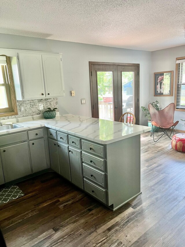 10624 56 1/2 St, Palmer Twp, MN 55319 - kitchen with a peninsula, french doors, dark wood-style floors, a sink, and a textured ceiling