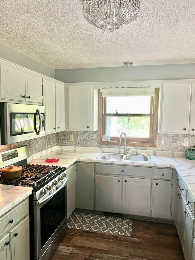10624 56 1/2 St, Palmer Twp, MN 55319 - kitchen featuring stainless steel appliances, a sink, a textured ceiling, dark wood-type flooring, and tasteful backsplash