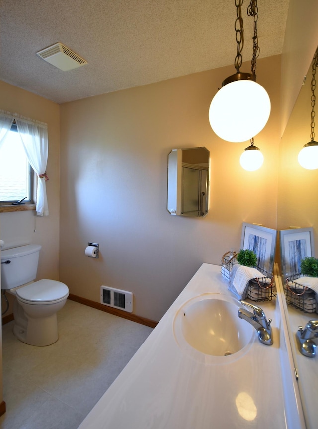 bathroom featuring baseboards, visible vents, a textured ceiling, and toilet