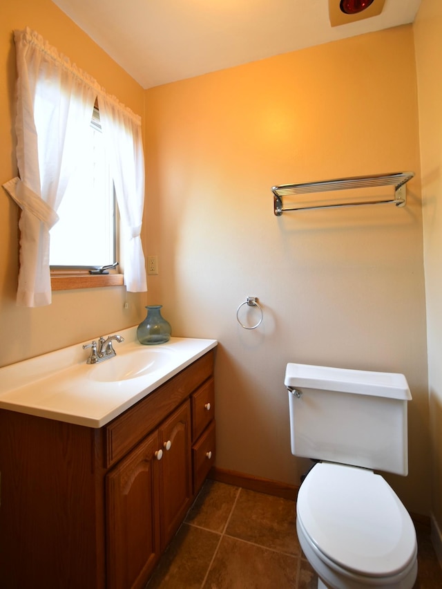 bathroom with tile patterned flooring, baseboards, toilet, and vanity