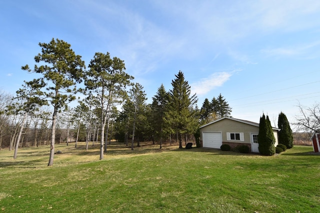 view of yard with a garage and an outbuilding
