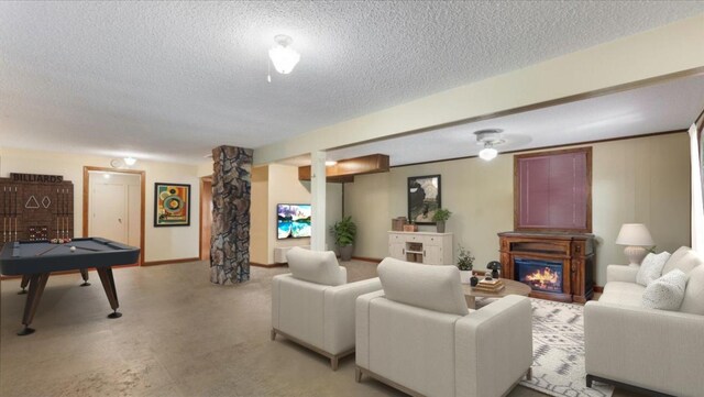 living area featuring a textured ceiling, light colored carpet, baseboards, and a warm lit fireplace