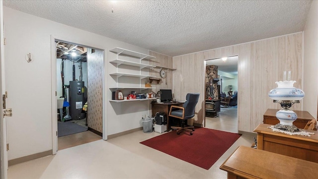office area with water heater, wood walls, and a textured ceiling