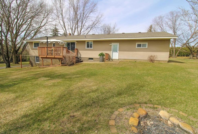 rear view of house with a lawn and a deck