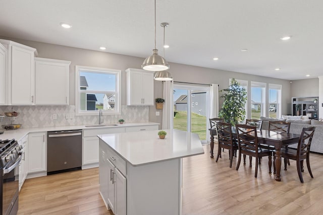 2141 Johanna Cir, Lino Lakes, MN 55038 - kitchen featuring light countertops, range with gas cooktop, a sink, light wood-style flooring, and dishwasher