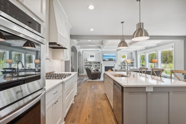 4233 Halstead Bay Alcove, Minnetrista, MN 55331 - kitchen featuring a sink, open floor plan, light countertops, a lit fireplace, and stainless steel appliances