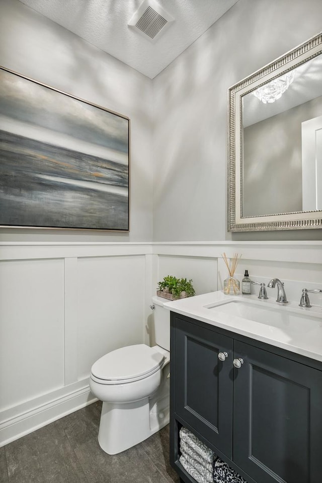 4233 Halstead Bay Alcove, Minnetrista, MN 55331 - half bathroom with a decorative wall, toilet, vanity, and a wainscoted wall