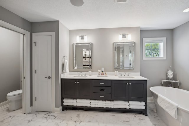 4233 Halstead Bay Alcove, Minnetrista, MN 55331 - full bathroom featuring marble look tiles, a soaking tub, double vanity, baseboards, and a textured ceiling