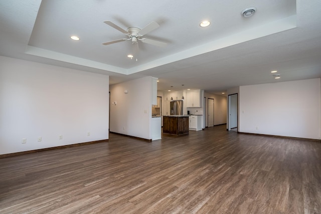 209 Plum Run, Le Sueur, MN 56058 - unfurnished living room with a tray ceiling, baseboards, a ceiling fan, dark wood-style floors, and recessed lighting
