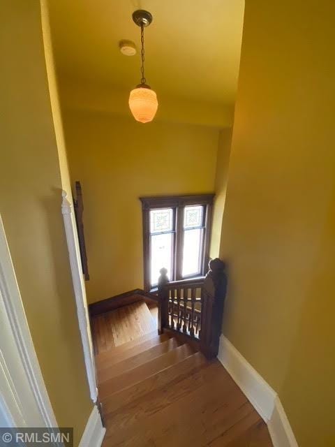 stairway with baseboards and wood finished floors