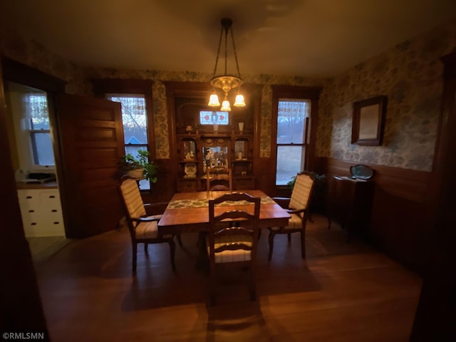 dining room featuring wainscoting, wallpapered walls, a wealth of natural light, and a chandelier