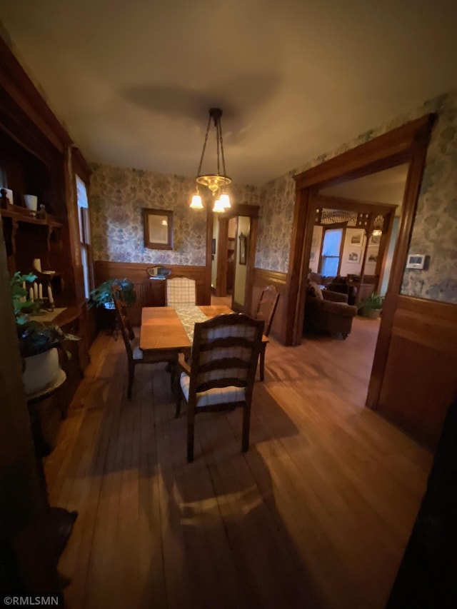 dining space featuring a wainscoted wall and wallpapered walls
