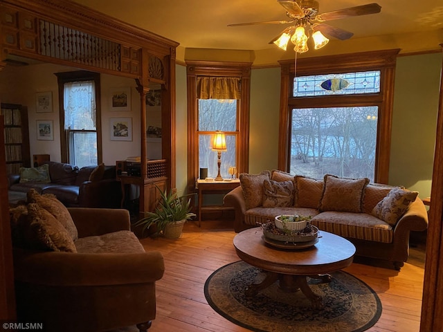 living area featuring light wood-type flooring and a ceiling fan