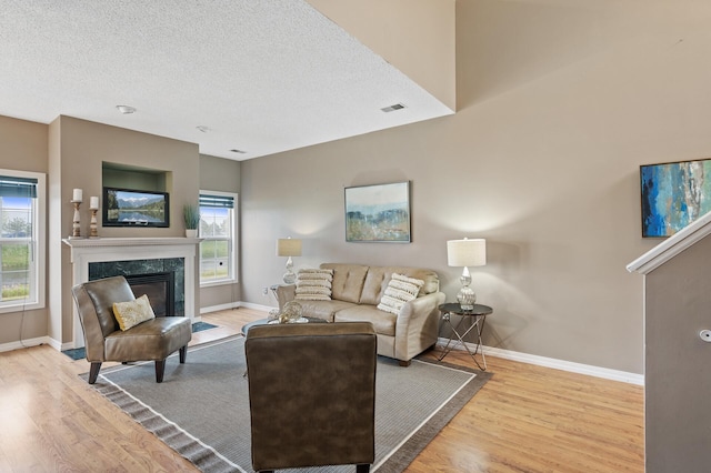 7619 Derby Ln, Shakopee, MN 55379 - living area featuring wood finished floors, baseboards, a high end fireplace, and a textured ceiling