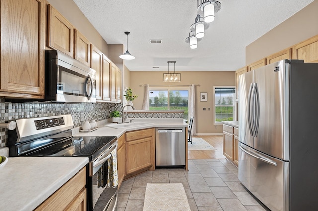 7619 Derby Ln, Shakopee, MN 55379 - kitchen featuring stainless steel appliances, a sink, tasteful backsplash, light countertops, and a peninsula