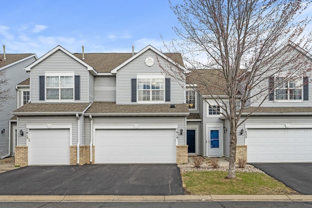 7619 Derby Ln, Shakopee, MN 55379 - view of front of home with driveway, brick siding, a garage, and roof with shingles