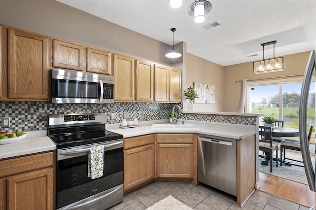 7619 Derby Ln, Shakopee, MN 55379 - kitchen featuring stainless steel appliances, a sink, a peninsula, light countertops, and a textured ceiling