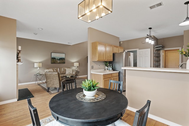 7619 Derby Ln, Shakopee, MN 55379 - dining space featuring light wood-style flooring, baseboards, and a chandelier