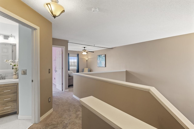7619 Derby Ln, Shakopee, MN 55379 - hall featuring light carpet, an upstairs landing, baseboards, and a textured ceiling