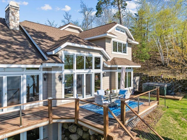 rear view of property featuring roof with shingles, a deck, a chimney, and french doors