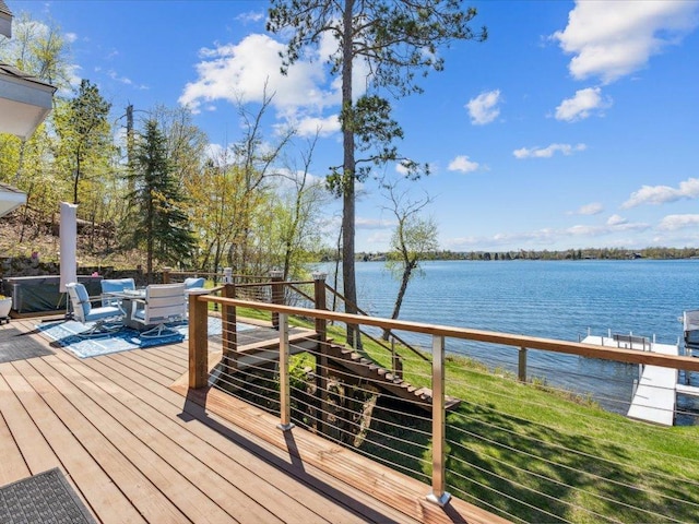 wooden terrace with a water view and stairway