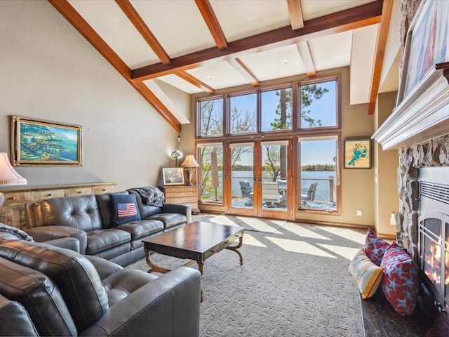 living room with a high ceiling, a fireplace, beamed ceiling, a water view, and baseboards