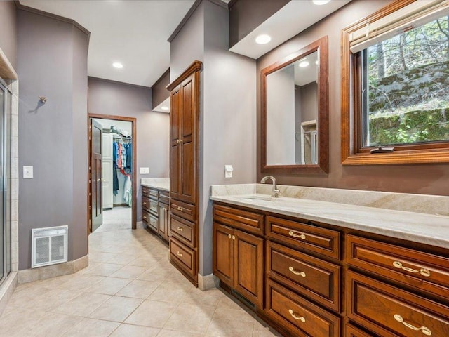 full bath with vanity, tile patterned flooring, a walk in closet, a shower stall, and baseboards