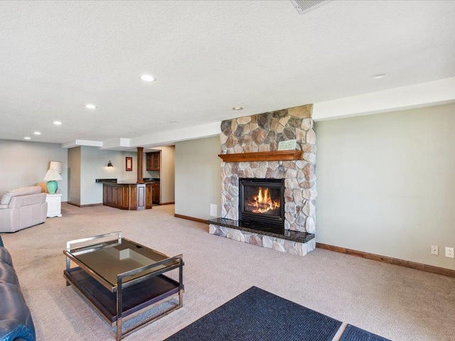 carpeted living area featuring a fireplace, baseboards, recessed lighting, and a textured ceiling