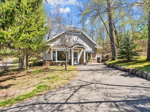 view of front of house with stone siding and driveway