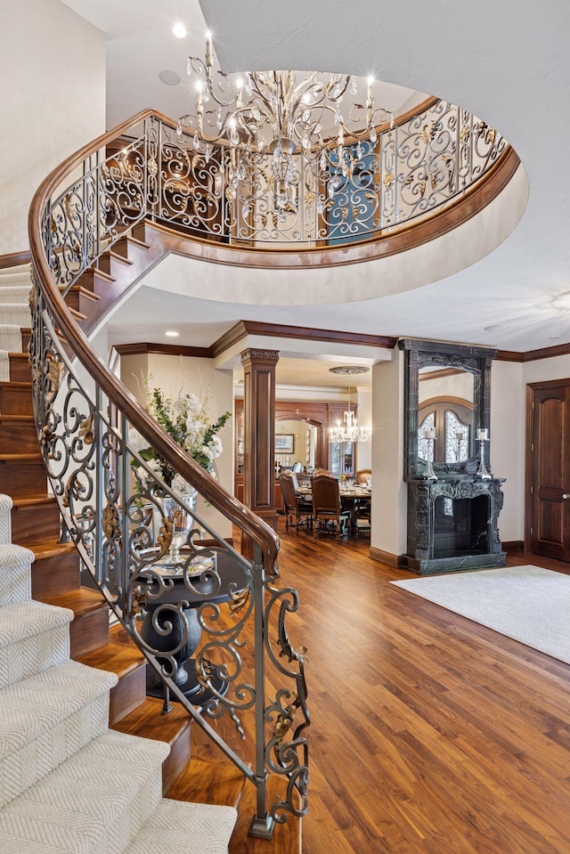 614 Hidden Creek Trl, Mendota Heights, MN 55118 - stairs with a chandelier, ornamental molding, a high ceiling, a fireplace, and wood finished floors