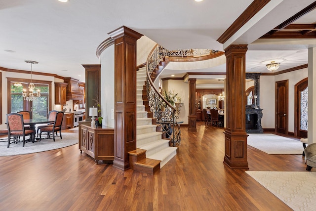 614 Hidden Creek Trl, Mendota Heights, MN 55118 - entrance foyer with ornate columns, a chandelier, ornamental molding, dark wood-type flooring, and stairs