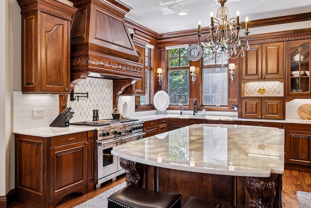 614 Hidden Creek Trl, Mendota Heights, MN 55118 - kitchen with range with two ovens, a chandelier, dark wood finished floors, a kitchen island, and tasteful backsplash