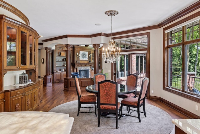 614 Hidden Creek Trl, Mendota Heights, MN 55118 - dining area with ornate columns, a chandelier, crown molding, dark wood-type flooring, and a glass covered fireplace