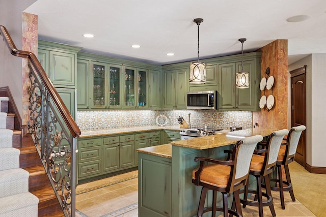 614 Hidden Creek Trl, Mendota Heights, MN 55118 - kitchen featuring stainless steel microwave, green cabinets, range, a kitchen bar, and pendant lighting