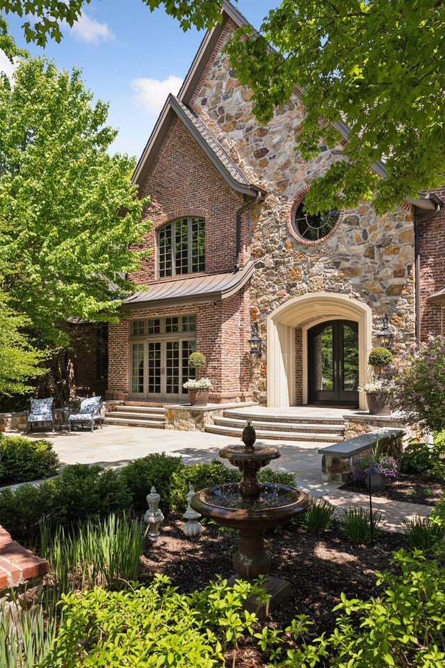 614 Hidden Creek Trl, Mendota Heights, MN 55118 - back of property featuring french doors, a patio area, stone siding, and brick siding