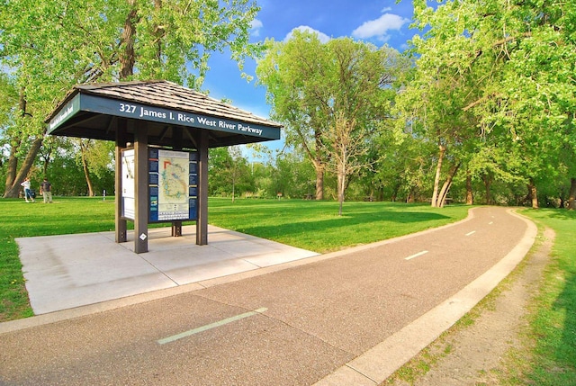 view of property's community with a yard and view of wooded area