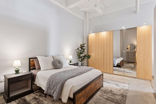 bedroom featuring a high ceiling, beamed ceiling, and a ceiling fan