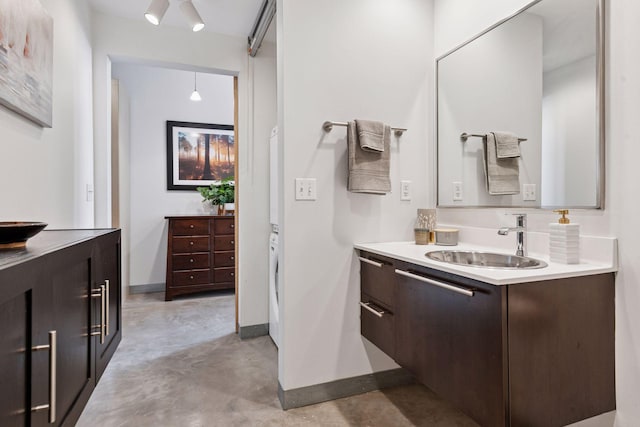 bathroom featuring concrete floors, baseboards, and vanity