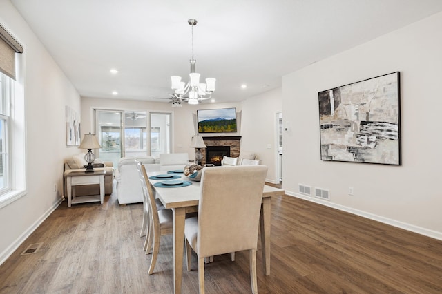 17865 Graphite Ln, Lakeville, MN 55044 - dining area with a stone fireplace, visible vents, wood finished floors, and a notable chandelier