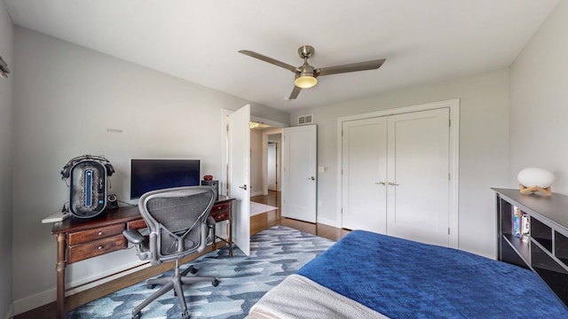 bedroom featuring ceiling fan, visible vents, baseboards, and a closet
