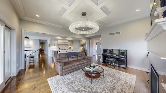living room with visible vents, ornamental molding, wood finished floors, baseboards, and coffered ceiling