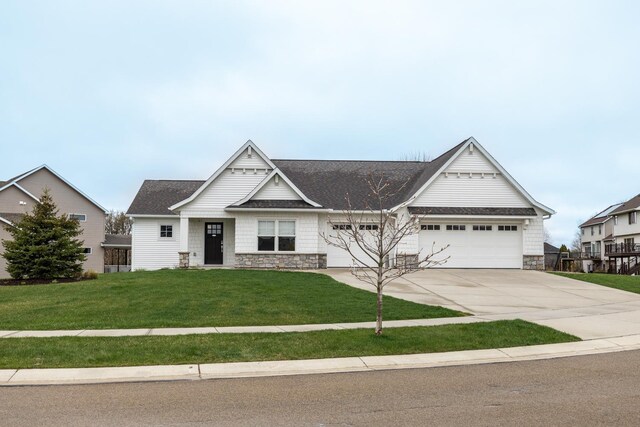craftsman inspired home with driveway, a garage, a front lawn, a shingled roof, and stone siding
