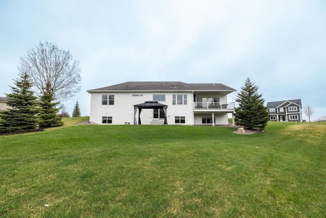 back of property with a gazebo, a yard, and a balcony