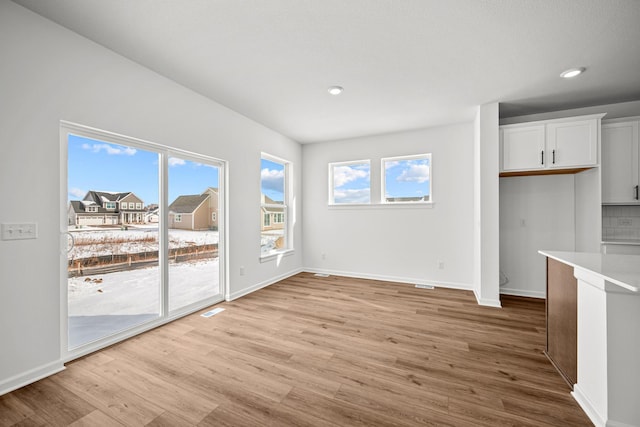 unfurnished dining area with baseboards, light wood-style floors, visible vents, and recessed lighting