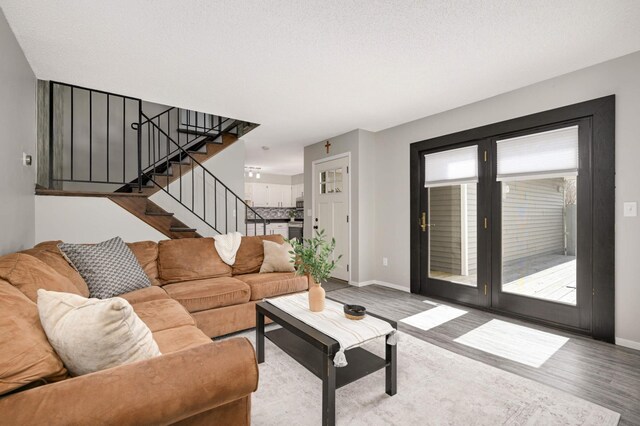 living room with wood finished floors, stairs, and baseboards