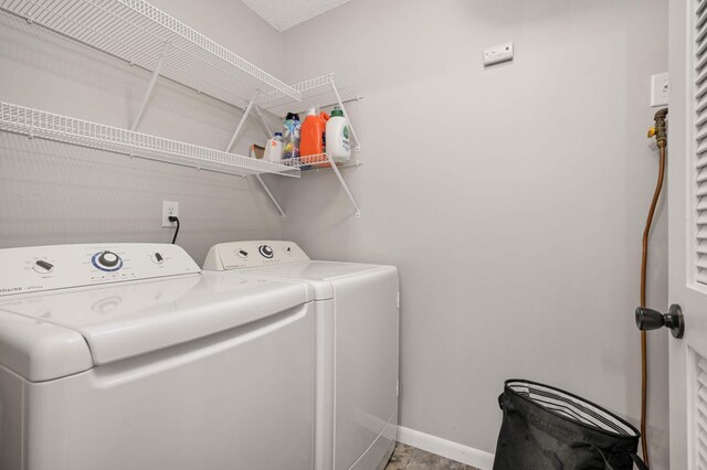 clothes washing area featuring baseboards, laundry area, and independent washer and dryer